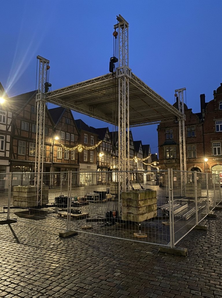 Photo recorded against the temporary structures and rigging hazard: Stage deck and ground-support roof, 10 m by 8 m, centre of the Market Place