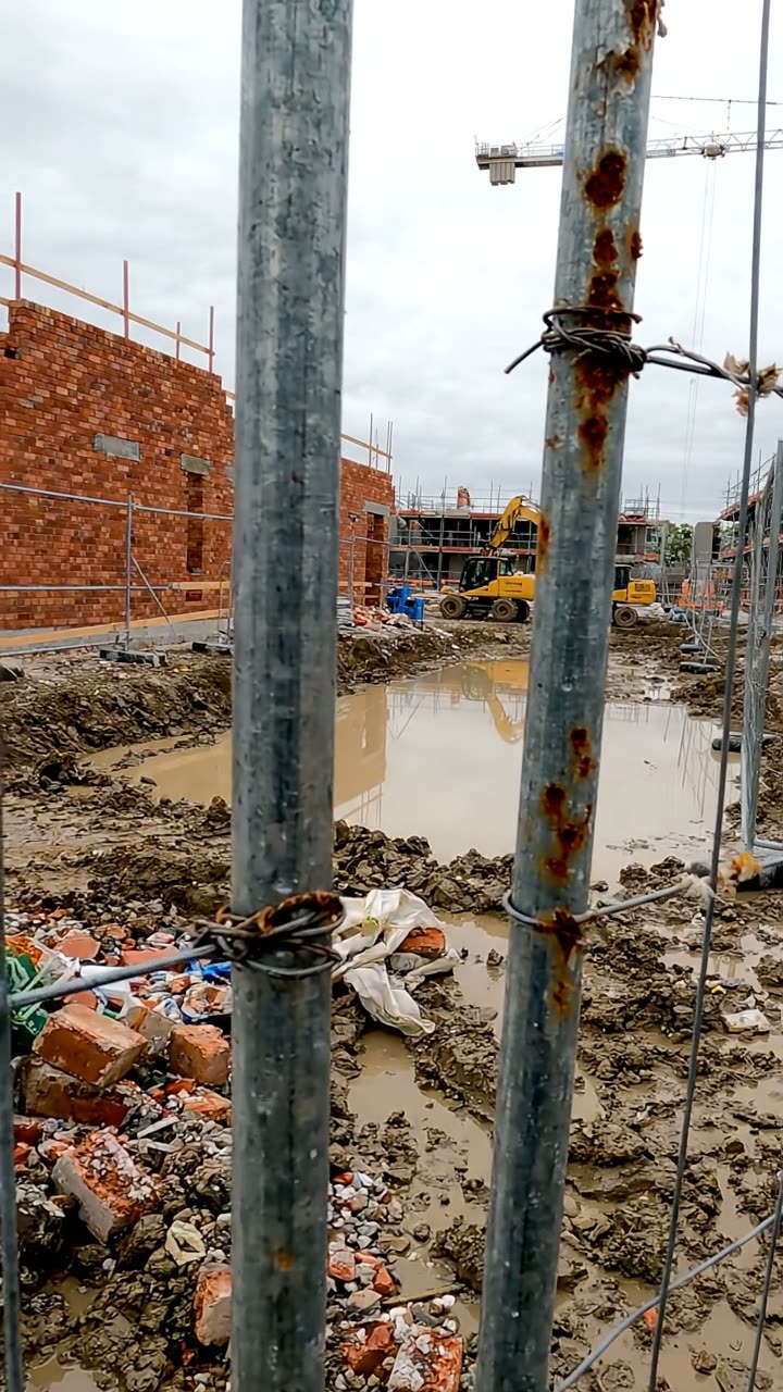 Mesh fence panels on block feet at the edge of a construction site